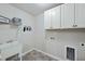 Functional laundry room with utility sink, white cabinets, and washer/dryer hookups for convenience at 1720 Highpoint St, Wake Forest, NC 27587