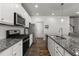 Modern kitchen with granite countertops, stainless steel appliances, and white cabinetry at 1805 Kauri Cliffs Dr, Fuquay Varina, NC 27526