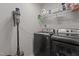 Laundry room with a modern washer, dryer, and Dyson cordless vacuum at 1805 Kauri Cliffs Dr, Fuquay Varina, NC 27526