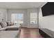 Inviting living room featuring a sectional sofa, wood floors, and natural light at 1805 Kauri Cliffs Dr, Fuquay Varina, NC 27526