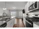 Modern, open-concept kitchen flowing into the living area with wood flooring at 1805 Kauri Cliffs Dr, Fuquay Varina, NC 27526