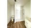 Bright bathroom featuring a shower, toilet, and sink with white cabinetry and wood-look flooring at 216 S Tillery St, Rocky Mount, NC 27804