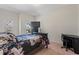 Cozy bedroom featuring a floral comforter, desk, and a TV on top of a dresser at 2216 Tanners Mill Dr, Durham, NC 27703