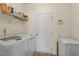 Functional laundry room with washer, dryer, and overhead shelving for storage at 2216 Tanners Mill Dr, Durham, NC 27703