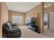 Comfortable living room featuring a large window, a black leather sofa, and a modern entertainment center at 2216 Tanners Mill Dr, Durham, NC 27703