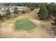 An aerial view of a golf course green and sand trap surrounded by grassy lawns and scattered trees at 2245 Ventana Ln, Raleigh, NC 27604
