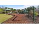 An inviting playground features a variety of play structures with a canopy and a swing set bordered with mulch at 2245 Ventana Ln, Raleigh, NC 27604