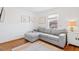 Bright living room with a gray sectional couch, hardwood floors, and modern art at 2330 Glascock St, Raleigh, NC 27610