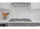 A close-up of a stovetop reveals sleek countertops and classic subway tile backsplash at 2330 Glascock St, Raleigh, NC 27610