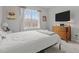 Bedroom with a large window, a TV, a dresser, and a bed dressed in a white duvet and gray throw at 240 Northview Dr, Middlesex, NC 27557