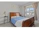Bedroom with a wooden bed frame dressed in a blue duvet, a window and an end table at 240 Northview Dr, Middlesex, NC 27557