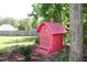 Charming red birdhouse hanging in a lush green yard with surrounding landscape at 240 Northview Dr, Middlesex, NC 27557