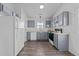 Well-lit kitchen with stainless steel appliances, light gray cabinets, and hardwood floors at 2613 Lilymount Dr, Raleigh, NC 27610