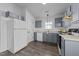 Well-lit kitchen with stainless steel appliances, grey cabinets, and hardwood floors at 2613 Lilymount Dr, Raleigh, NC 27610