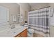 Well-lit bathroom featuring a single vanity, a toilet, and a shower with a stylish curtain at 2914 Lake James Dr, Fuquay Varina, NC 27526