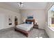 Cozy bedroom with a wood frame bed, bedside tables, and serene mountain artwork at 2914 Lake James Dr, Fuquay Varina, NC 27526