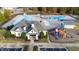 Aerial view of a community pool area with multiple pools, a playset, and a modern clubhouse for residents at 2914 Lake James Dr, Fuquay Varina, NC 27526