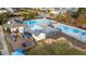 Aerial view of a community pool area with multiple pools, a playset, and a bathhouse for residents at 2914 Lake James Dr, Fuquay Varina, NC 27526