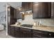 Close-up of the kitchen with granite countertops, dark wood cabinets, and stainless steel range hood at 3001 Valleystone Dr, Cary, NC 27519