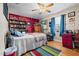 A colorful bedroom with a ceiling fan, wooden floors, a bookshelf and a colorful rug at 3030 Old Stage S Rd, Erwin, NC 28339