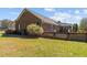 View of brick home exterior, showcasing the side yard and connecting outdoor patio area at 3030 Old Stage S Rd, Erwin, NC 28339