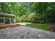 Lush backyard featuring a patio, screened porch, well-manicured lawn, and mature trees at 306 Lochside Dr, Cary, NC 27518