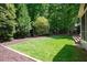 Manicured backyard lawn with lush greenery and mature trees offering privacy at 306 Lochside Dr, Cary, NC 27518