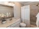 Bright bathroom featuring a vanity with stone countertop and a shower with neutral-toned tiling and white striped shower curtain at 306 Lochside Dr, Cary, NC 27518