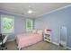 Bright bedroom with blue walls, white trim, carpet, and a large window allowing natural light at 306 Lochside Dr, Cary, NC 27518