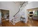 Bright foyer featuring hardwood floors, staircase, and views into the living spaces at 306 Lochside Dr, Cary, NC 27518