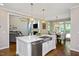 Open-concept kitchen with island, stainless sink, and view into living and dining areas at 306 Lochside Dr, Cary, NC 27518