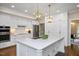 Bright kitchen features stainless steel appliances, spacious island, and stylish pendant lighting at 306 Lochside Dr, Cary, NC 27518