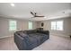 Spacious living room with a gray sectional, ceiling fan and multiple windows allowing natural light at 306 Lochside Dr, Cary, NC 27518