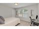 A cozy bedroom featuring a practical workspace, including a desk and comfortable chair by a bright window at 31 E Dentaires Way, Willow Springs, NC 27592