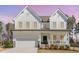 Charming two-story white farmhouse with a welcoming front porch and well-maintained landscaping at 31 E Dentaires Way, Willow Springs, NC 27592