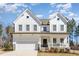 Charming two-story white farmhouse with a welcoming front porch and well-maintained landscaping at 31 E Dentaires Way, Willow Springs, NC 27592