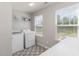 Laundry room with washer, dryer, patterned floor, shelving and natural light from the window at 31 E Dentaires Way, Willow Springs, NC 27592