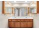 Bathroom vanity with double sinks, wood cabinets, and large mirror at 3308 Forest Mill Cir, Raleigh, NC 27616