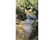 Charming creek with clear, flowing water and natural rock formations, creating a peaceful environment at 3308 Forest Mill Cir, Raleigh, NC 27616