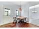 Bright dining area with a wood table and metal chairs near a door and window at 3308 Forest Mill Cir, Raleigh, NC 27616
