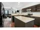 Modern kitchen open to the living area, featuring an island, dark wood cabinets and stainless steel appliances at 3308 Forest Mill Cir, Raleigh, NC 27616