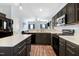Open kitchen with black appliances, cabinets, white countertops, and wood-look floors at 3308 Forest Mill Cir, Raleigh, NC 27616