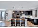 Modern kitchen with stainless steel appliances, dark cabinetry, and a large white quartz island with pendant lighting at 3417 Mission Olive Pl, New Hill, NC 27562
