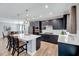 Stylish eat-in kitchen with stainless steel appliances, dark cabinets, quartz counters and island seating at 3417 Mission Olive Pl, New Hill, NC 27562