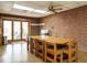 Dining area with a large wooden table, brick walls, and easy access to the outdoor patio at 3680 15-501 N, Pittsboro, NC 27312