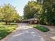 Driveway leads to the house and a covered brick outbuilding on a manicured lawn at 3680 15-501 N, Pittsboro, NC 27312