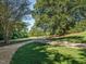 Long driveway leads through a beautiful, manicured lawn with mature trees at 3680 15-501 N, Pittsboro, NC 27312