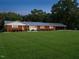 Brick home at dusk with manicured lawn, trimmed bushes and an attached carport at 3680 15-501 N, Pittsboro, NC 27312