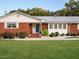 Inviting brick home featuring a blue front door and a meticulously maintained front yard at 3680 15-501 N, Pittsboro, NC 27312