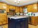 Bright kitchen featuring knotty pine cabinets, white countertops, and a navy island at 3680 15-501 N, Pittsboro, NC 27312